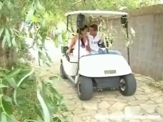 A prawan and her swain are driving around in a golep cart. suddenly they stop and the youngster begins to touch the prawan up,